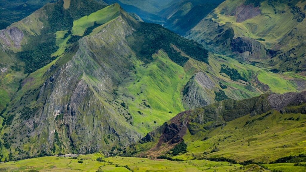 Aerial view of Papua New Guinea’s rugged mountain ranges and lush valleys, illustrating the isolated terrain that shaped the nation’s diverse languages.