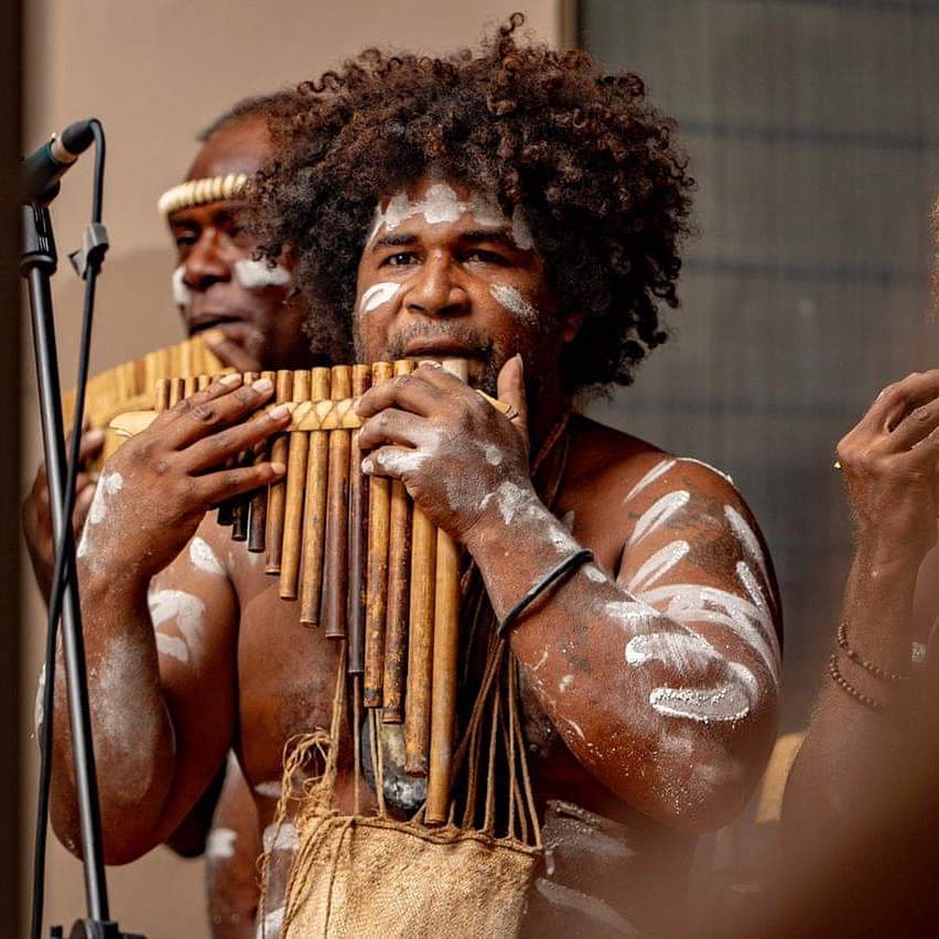 Solomon Islands musician playing traditional panpipes during a cultural festival, expressing island heritage.